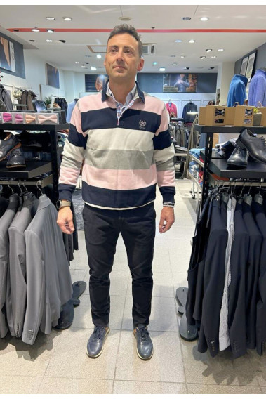 Homme portant le polo manches longues roses à rayures. col chemise et coupe classique.