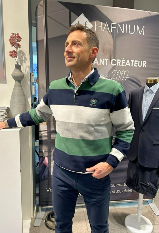 Homme portant le polo manches longues vert à rayures. Coupe classique.