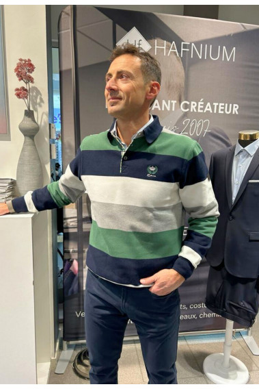 Homme portant le polo manches longues vert à rayures. Coupe classique.