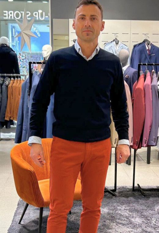 Homme portant le pull col V marine avec une chemise. Coupe regular.