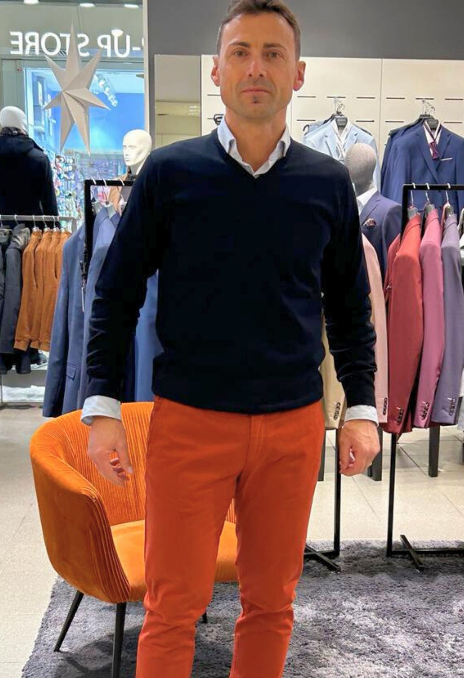 Homme portant le pull col V marine avec une chemise. Coupe regular.