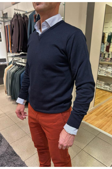 Homme portant le pull col V marine avec une chemise. Coupe regular.