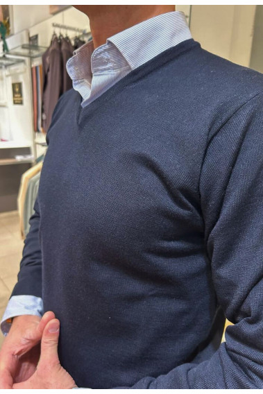 Homme portant le pull col V marine avec une chemise. Coupe regular.