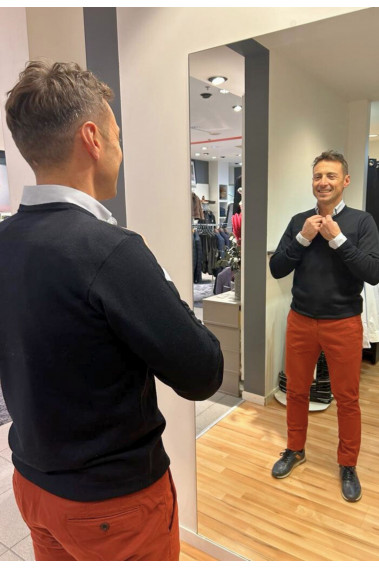 Homme portant le pull col V marine avec une chemise. Coupe regular.