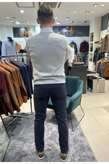 Homme de dos portant le pull col V gris clair avec une chemise. Coupe regular.