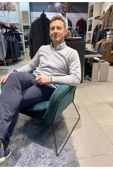 Homme portant le pull col V gris clair avec une chemise. Coupe regular.