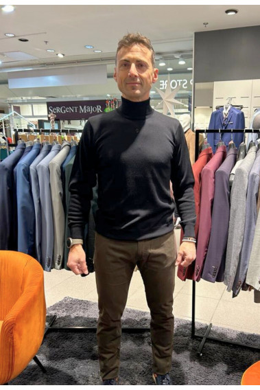 Homme portant le col roulé noir. Coupe regular.