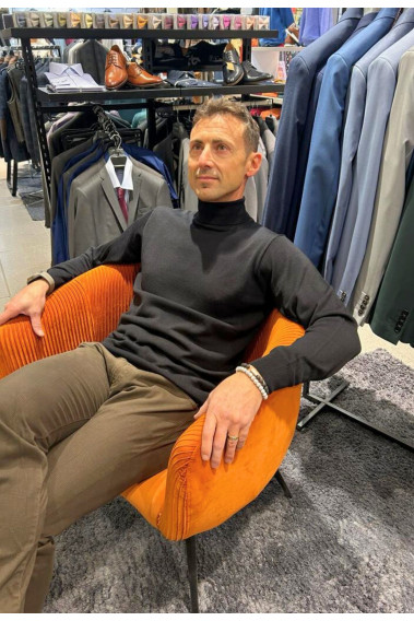Homme portant le col roulé noir. Coupe regular.
