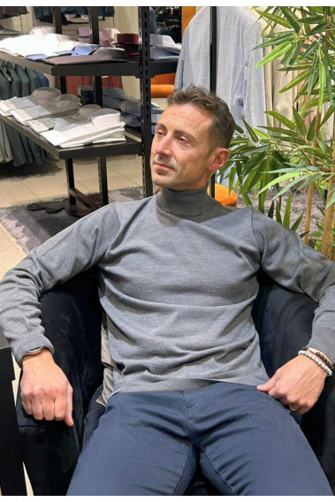 Homme portant le col roulé gris clair. Coupe regular.