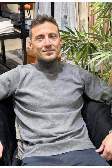 Homme portant le col roulé gris clair. Coupe regular.