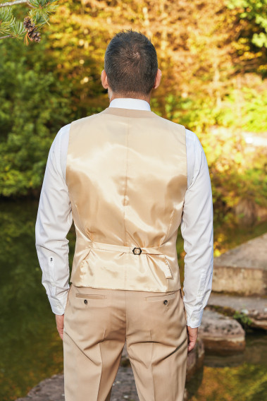 Homme de dos portant le gilet CHRIS beige sable avec possibilité de le resserrer.