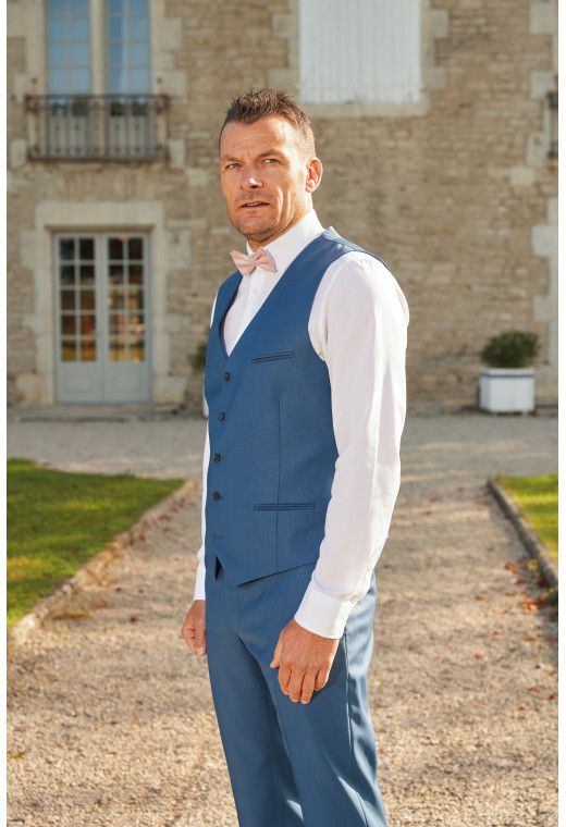 Homme portant le gilet CHRIS bleu accompagné d'un nœuds papillon.