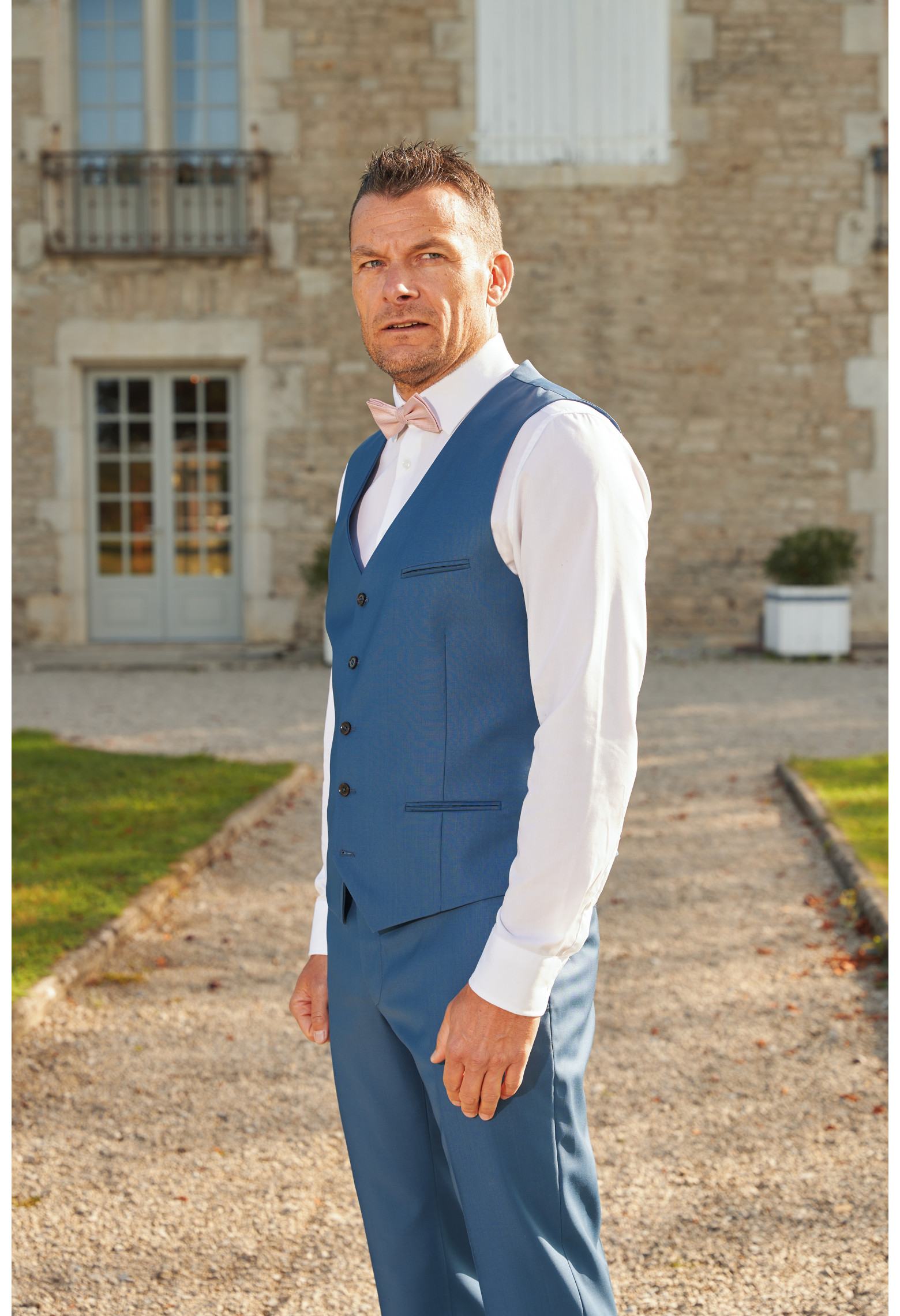 Homme portant le gilet CHRIS bleu accompagné d'un nœuds papillon.