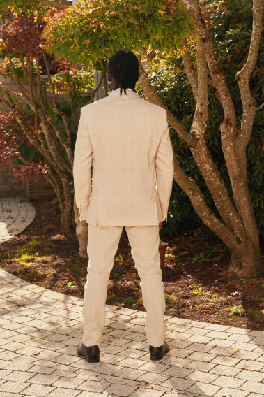 Homme de dos en costume GIORGIOC couleur beige dans une cours.