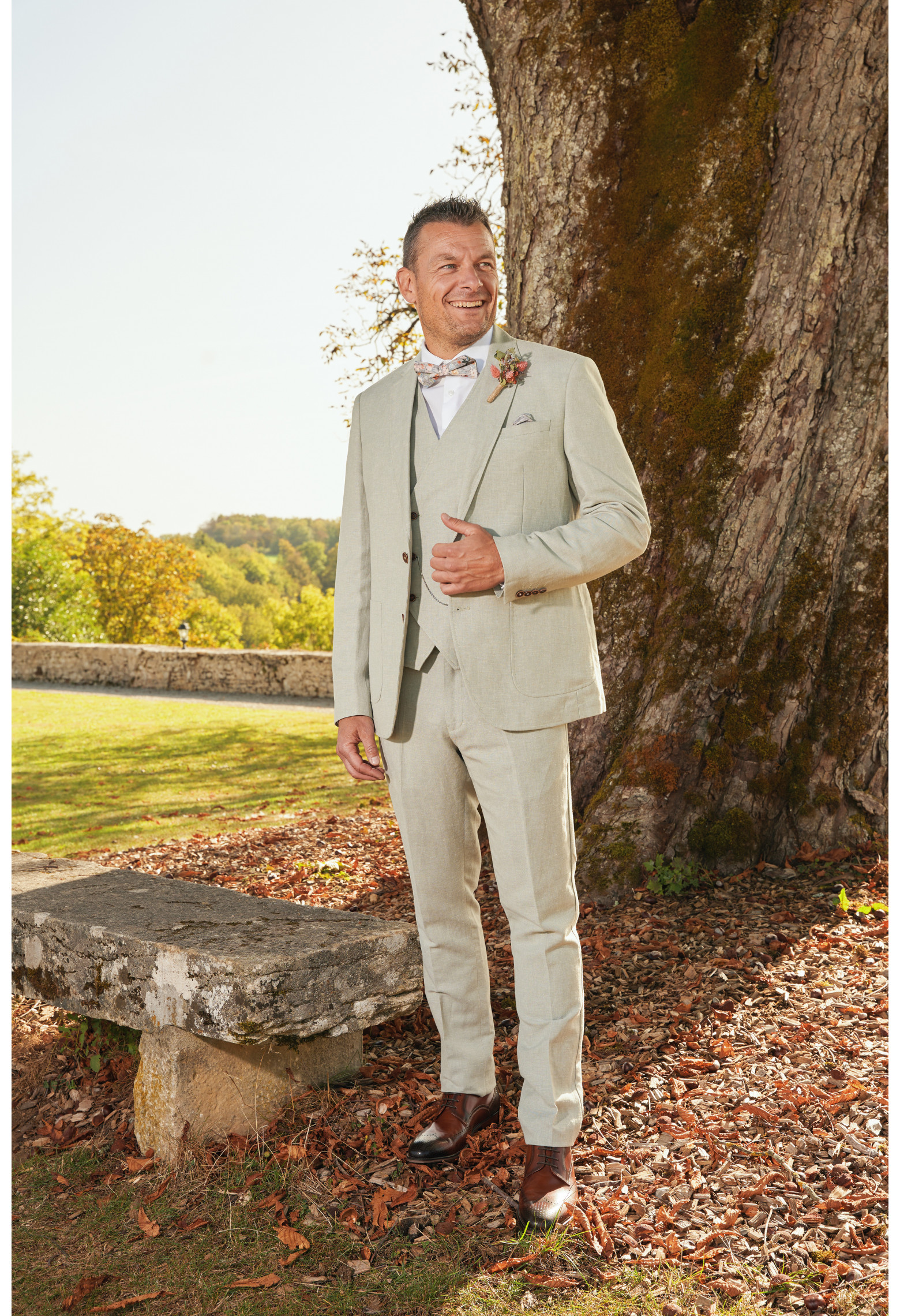 Homme de face en costume GIORGIO couleur vert 3 pièces devant un arbre.