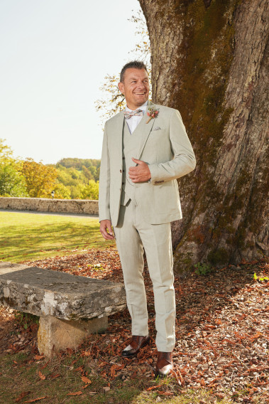Homme de face en costume GIORGIO couleur vert 3 pièces devant un arbre.