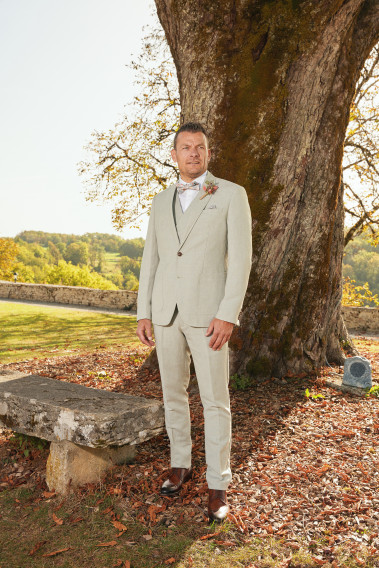 Homme de face en costume GIORGIO couleur vert 3 pièces devant un arbre.