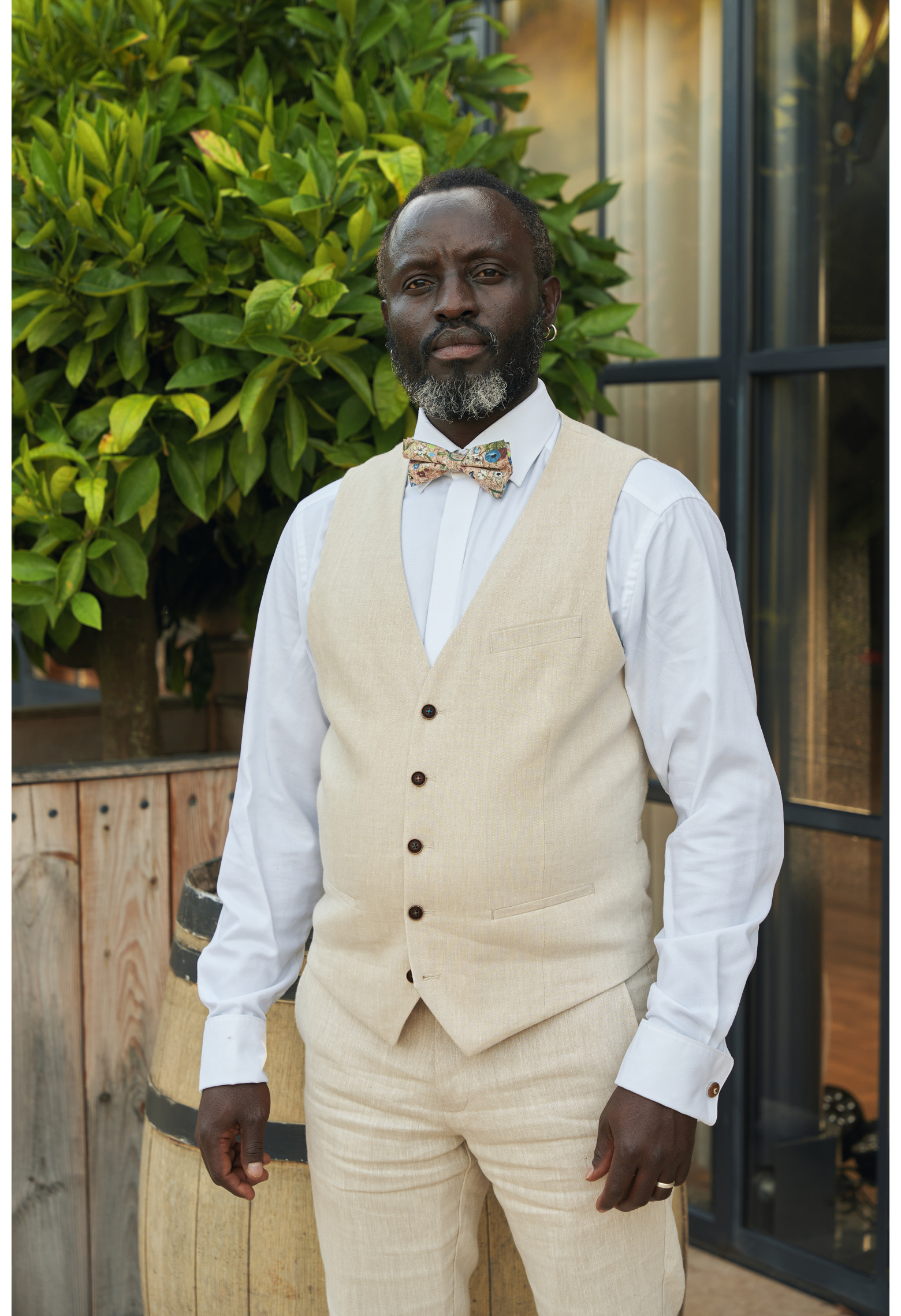 Homme portant le gilet LYMA armuré beige accompagné d'un nœuds papillon.
