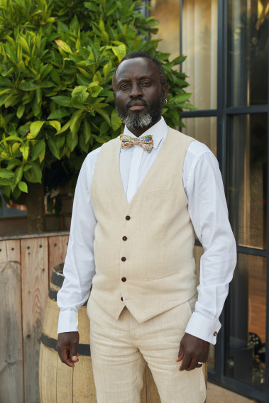 Homme portant le gilet LYMA armuré beige accompagné d'un nœuds papillon.