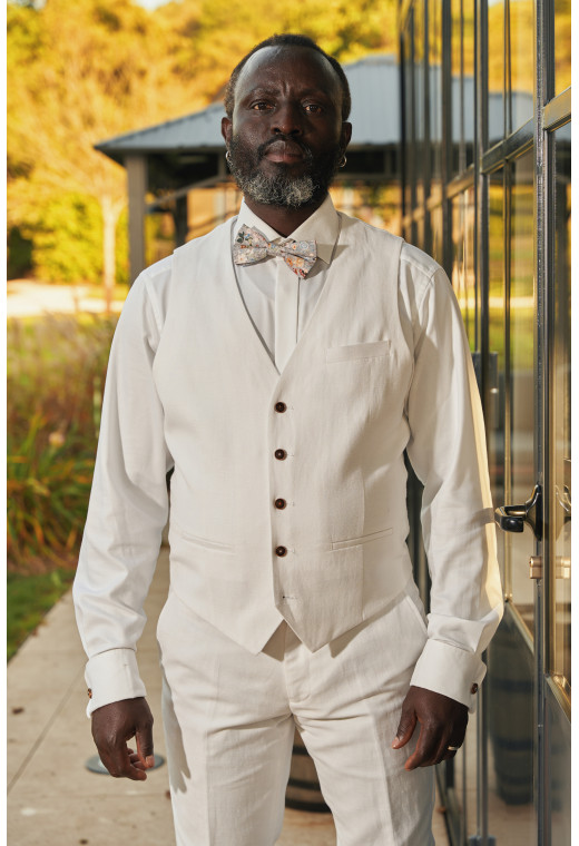 Homme portant le gilet LYMA blanc accompagné d'un nœuds papillon.