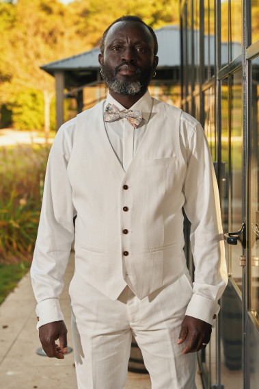 Homme portant le gilet LYMA blanc accompagné d'un nœuds papillon.