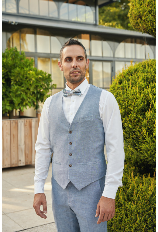 Homme portant le gilet LYMAW bleu accompagné d'un nœuds papillon.