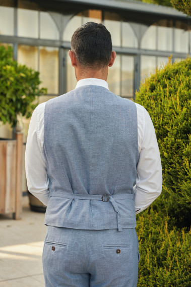 Homme de dos portant le gilet  LYMAW bleu avec possibilité de le resserrer.