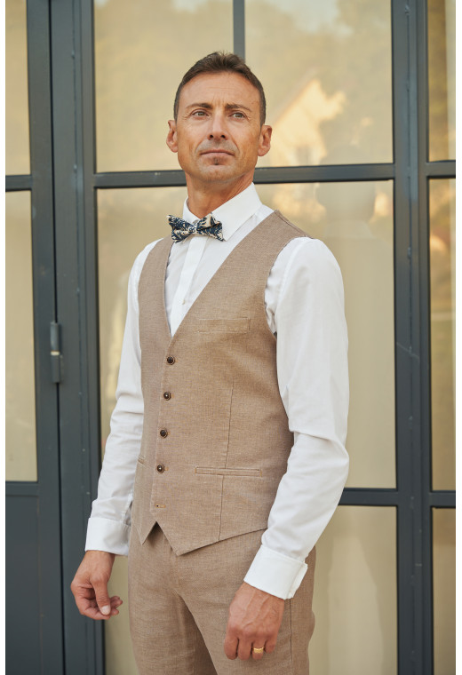 Homme portant le gilet LYMAW brun accompagné d'un nœuds papillon.