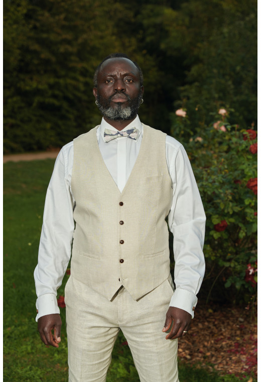 Homme portant le gilet LYMAW beige accompagné d'un nœuds papillon.