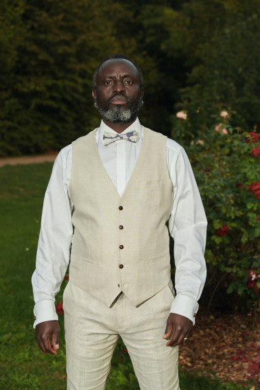 Homme portant le gilet LYMAW beige accompagné d'un nœuds papillon.