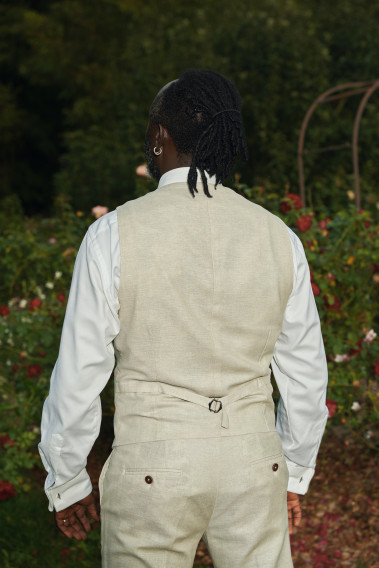 Homme de dos portant le  gilet LYMAW beige avec possibilité de le resserrer.