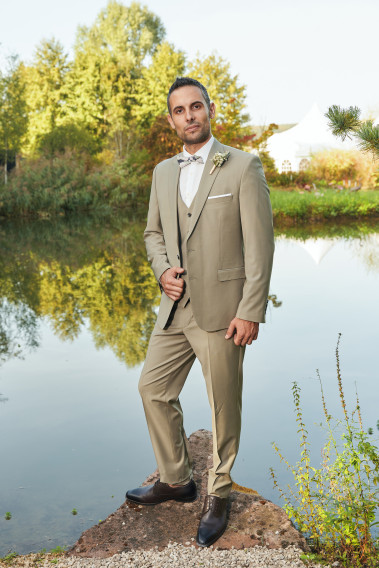 Homme de face en costume SUAT tilleul 3 pièces vers un lac.