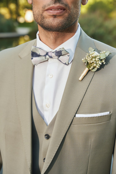 Costume SUAT tilleul. Plan sur la veste avec accessoire nœud papillon a motif et pins bouquet de fleur.