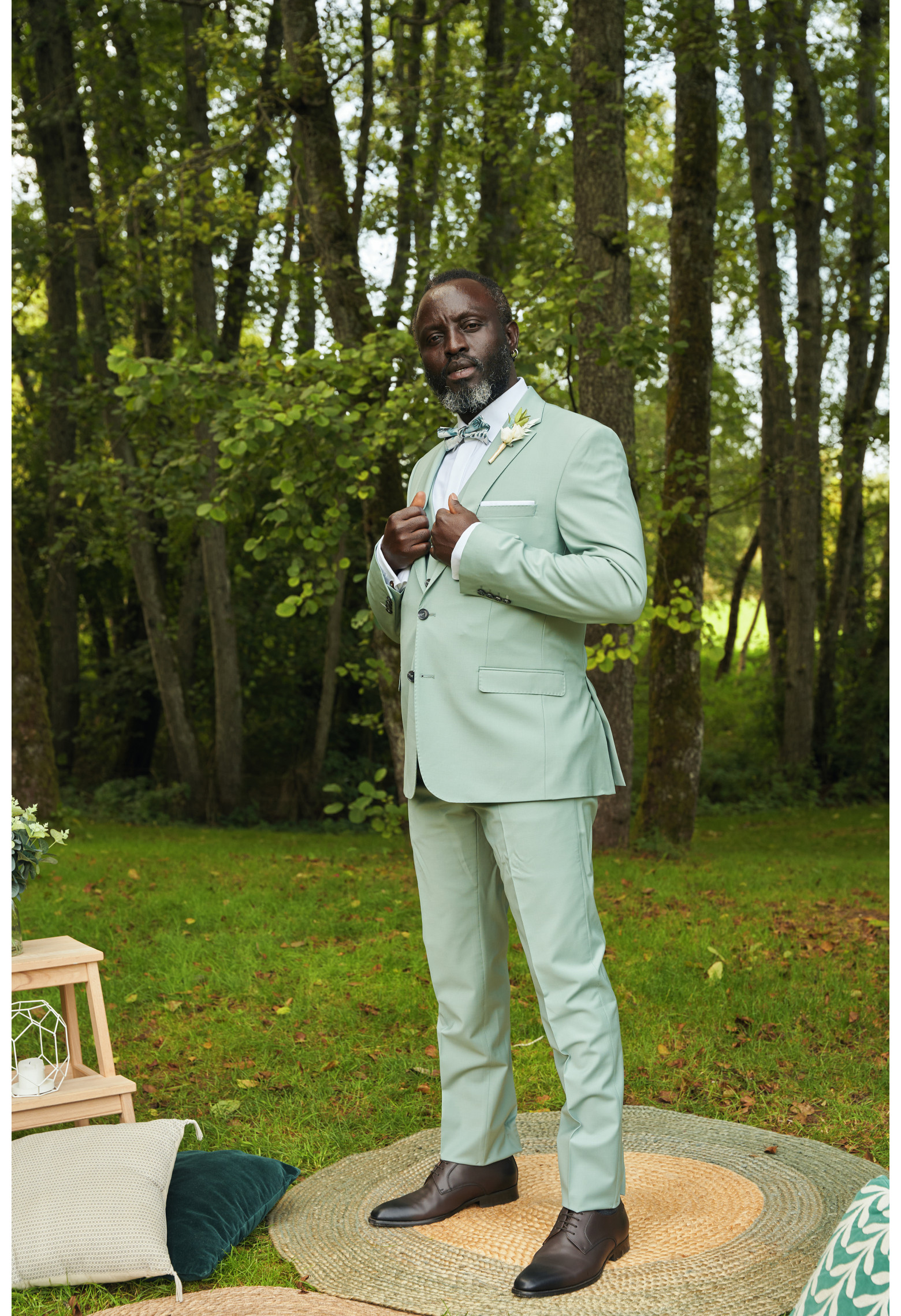 Homme de face en costume SUAT couleur vert d'eau 3 pièces dans un parc.