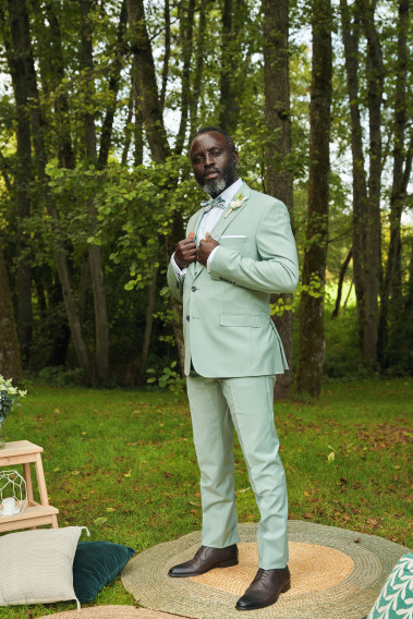 Homme de face en costume SUAT couleur vert d'eau 3 pièces dans un parc.