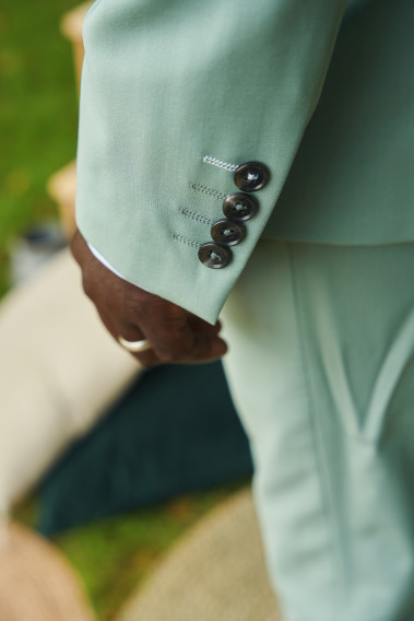 Costume SUAT vert d'eau. Plan sur les détails des boutons de la manche, boutons marrons sur veste verte.