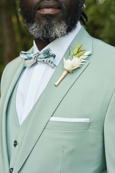Costume SUAT vert d'eau. Gros plan sur la veste avec pins bouquet de fleur et nœud papillon.