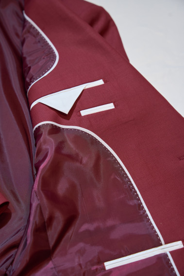 Zoom sur l’intérieur de la veste de costume SUAT couleur framboise. Elle comporte une doublure et 3 poches intérieures.