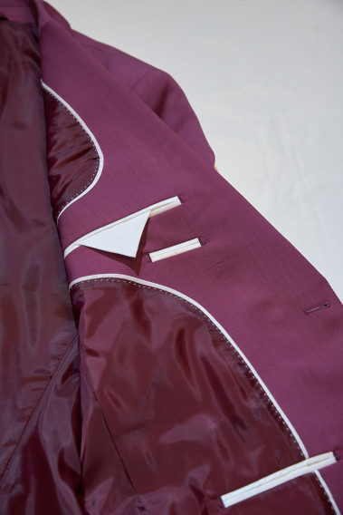 Zoom sur l’intérieur de la veste de costume SUAT couleur fushia. La doublure est fushia, elle comporte 3 poches intérieures.