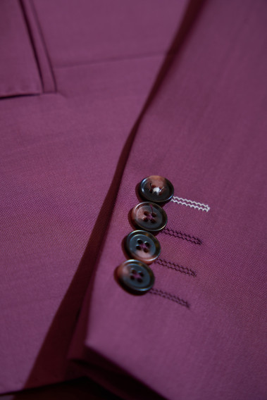 Zoom sur la manche du costume SUAT couleur fushia. Elle comporte 4 boutons marrons.