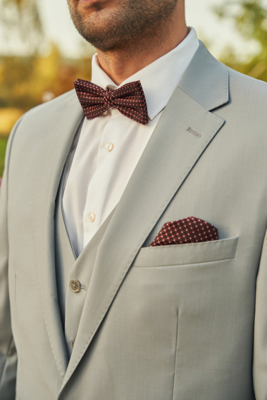 Costume SUAT gris clair. Plan sur le nœuds papillon  et son mouchoir de poche.