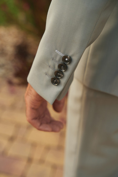 Costume SUAT gris clair. Plan de la manche sur les boutons de couleur noir.