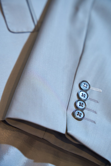 Costume SUAT gris clair. Plan de la manche sur les boutons de couleur noir.