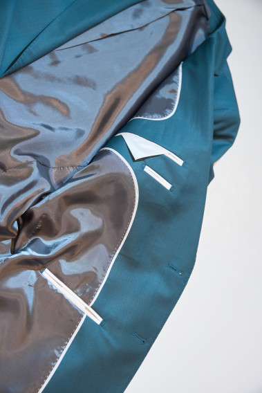 Zoom sur l’intérieur de la veste de costume SUAT couleur vert bleuté. La doublure est noir, elle comporte 3 poches intérieures.