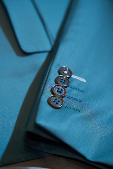 Zoom sur la manche du costume SUAT couleur vert bleuté. Elle comporte 4 boutons.