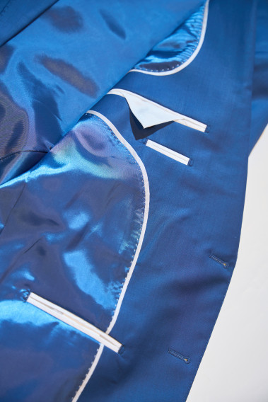 Zoom sur l’intérieur de la veste de costume SUAT couleur bleu. La doublure est bleu, elle comporte 3 poches intérieures.
