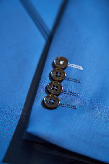 Zoom sur la manche du costume SUAT couleur bleu. Elle comporte 4 boutons noir.