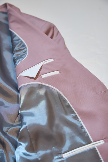 Zoom sur l’intérieur de la veste de costume SUAT couleur rose pâle. La doublure est grise, elle comporte 3 poches intérieures.