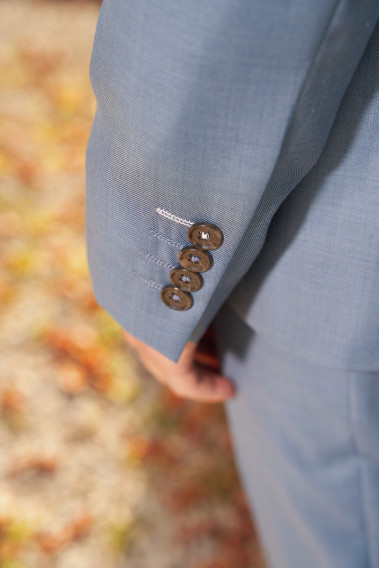 Zoom sur la manche du costume SUAT couleur bleu orage. Elle comporte 4 boutons noirs.