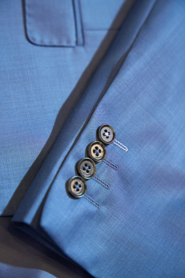 Zoom sur la manche du costume SUAT couleur bleu orage. Elle comporte 4 boutons noirs.